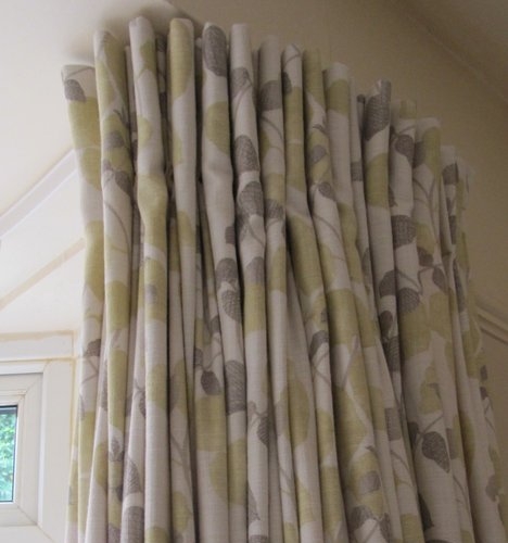 Handmade pinch pleated curtains inVilla Nova fabric fitted on a metal track which has been reverse bent around a bay window in Goring By Sea in Goring
